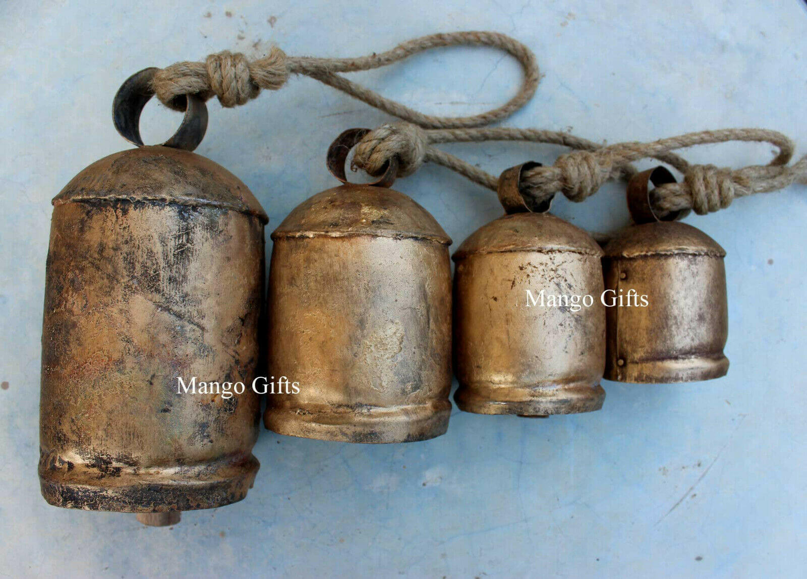 Set of 4 vintage handmade rustic giant cow bells with jute rope and antique gold finish. Perfect for garden decorations.